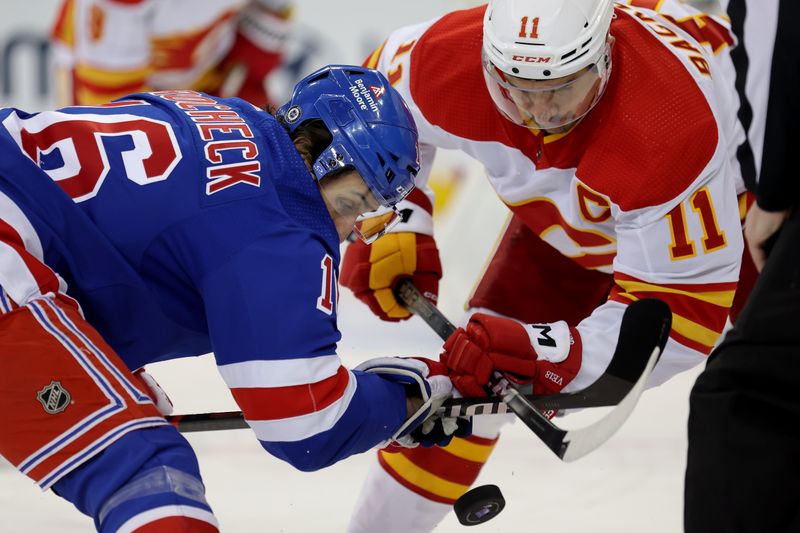 Feb 12, 2024; New York, New York, USA; New York Rangers center Vincent Trocheck (16) and Calgary Flames center Mikael Backlund (11) take a face-off during the first period at Madison Square Garden. Mandatory Credit: Brad Penner-USA TODAY Sports