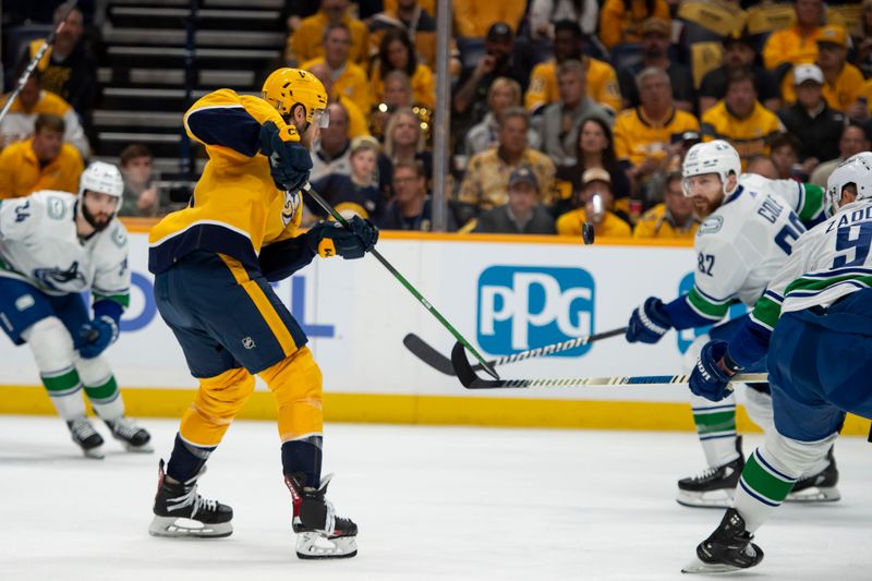 May 3, 2024; Nashville, Tennessee, USA; Nashville Predators defenseman Ryan McDonagh (27) and Vancouver Canucks defenseman Ian Cole (82) fight for the puck during the first period in game six of the first round of the 2024 Stanley Cup Playoffs at Bridgestone Arena. Mandatory Credit: Steve Roberts-USA TODAY Sports