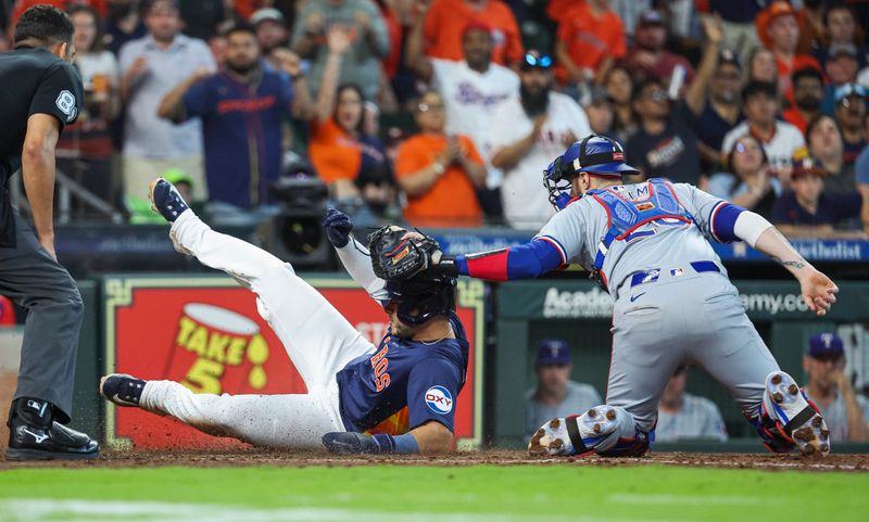 Apr 14, 2024; Houston, Texas, USA; Houston Astros designated hitter Yainer Diaz (21) is tagged out by Texas Rangers catcher Jonah Heim (28) on a play at the plate during the fifth inning at Minute Maid Park. Mandatory Credit: Troy Taormina-USA TODAY Sports