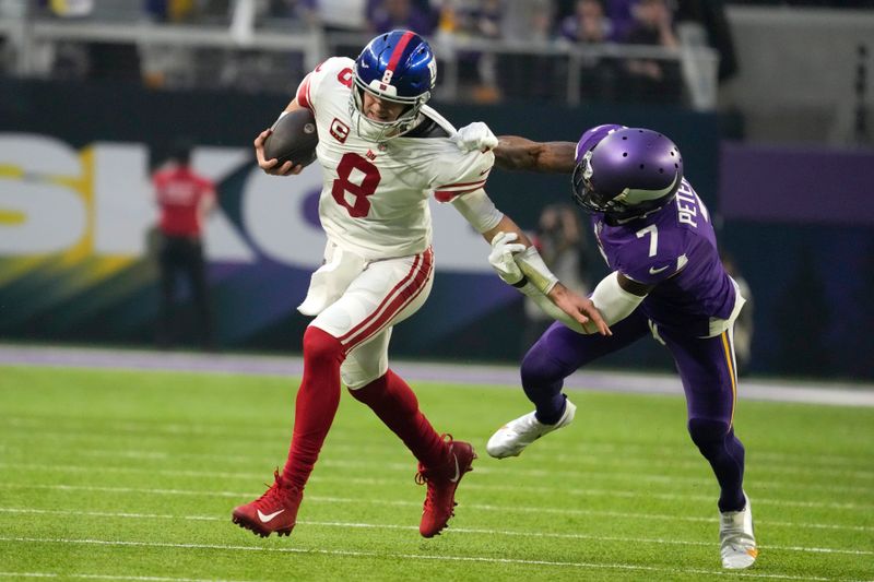 New York Giants quarterback Daniel Jones (8) tries to break a tackle by Minnesota Vikings cornerback Patrick Peterson (7) during the first half of an NFL wild card playoff football game, Sunday, Jan. 15, 2023, in Minneapolis. (AP Photo/Charlie Neibergall)