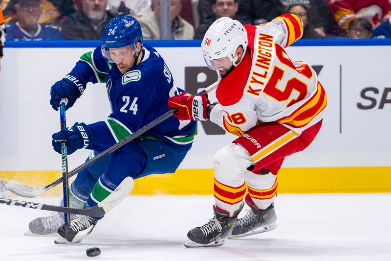 Apr 16, 2024; Vancouver, British Columbia, CAN; Calgary Flames defenseman Oliver Kylington (58) stick checks Vancouver Canucks forward Pius Suter (24) in the third period at Rogers Arena. Canucks won 4 -1. Mandatory Credit: Bob Frid-USA TODAY Sports