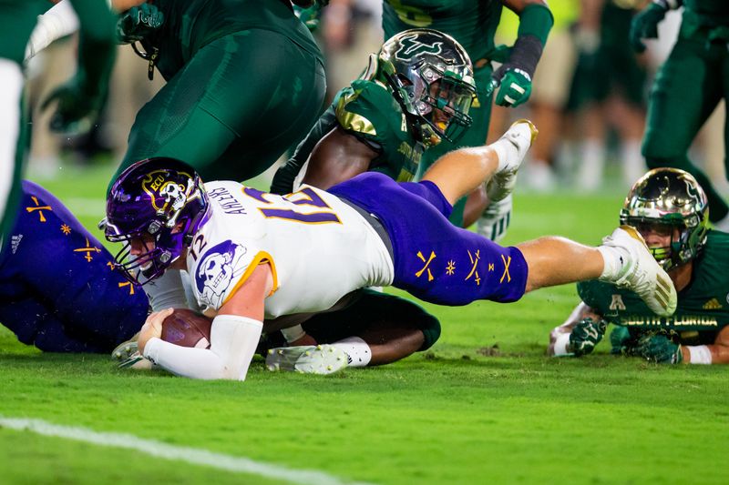 Oct 10, 2020; Tampa, Florida, USA; East Carolina Pirates quarterback Holton Ahlers (12) rushes during the first quarter of a game against the South Florida Bulls at Raymond James Stadium. Mandatory Credit: Mary Holt-USA TODAY Sports