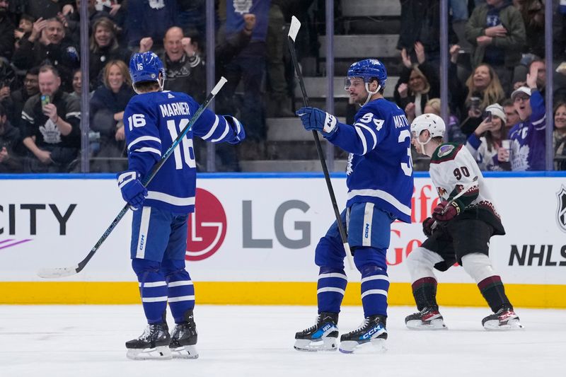 Feb 29, 2024; Toronto, Ontario, CAN; Toronto Maple Leafs forward Mitchell Marner (16) goes to congratulate forward Auston Matthews (34) after his goal against the Arizona Coyotes during the second period at Scotiabank Arena. Mandatory Credit: John E. Sokolowski-USA TODAY Sports