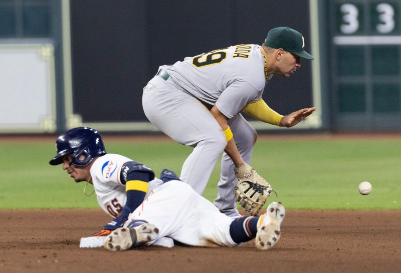 Sep 12, 2023; Houston, Texas, USA; Houston Astros center fielder Mauricio Dubon (14) slides into second base safely as Oakland Athletics first baseman Ryan Noda (49) awaits the throw at second base in the seventh inning at Minute Maid Park. Mandatory Credit: Thomas Shea-USA TODAY Sports