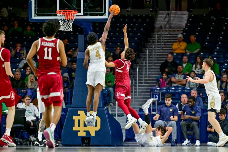 Mar 5, 2025; South Bend, Indiana, USA; Stanford Cardinal guard Oziyah Sellers (4) goes up for a shot as Notre Dame Fighting Irish guard Sir Mohammed (4) defends in the first half at the Purcell Pavilion. Notre Dame Fighting Irish guard Cole Certa (5) was called for a foul on the play. Mandatory Credit: Matt Cashore-Imagn Images