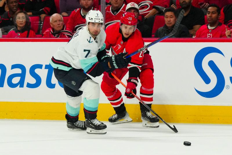 Oct 26, 2023; Raleigh, North Carolina, USA; Carolina Hurricanes center Sebastian Aho (20) and Seattle Kraken right wing Jordan Eberle (7) watch the puck during the first period at PNC Arena. Mandatory Credit: James Guillory-USA TODAY Sports