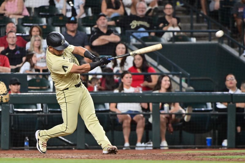 Jun 4, 2024; Phoenix, Arizona, USA;  Arizona Diamondbacks catcher Gabriel Moreno (14) hits a RBI single in the seventh inning against the San Francisco Giants at Chase Field. Mandatory Credit: Matt Kartozian-USA TODAY Sports