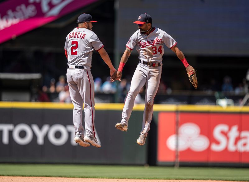 Jun 28, 2023; Seattle, Washington, USA; Washington Nationals centerfielder Derek Hill (34) and second baseman Luis Garcia (2) celebrate after a game against the Seattle Mariners at T-Mobile Park. Mandatory Credit: Stephen Brashear-USA TODAY Sports