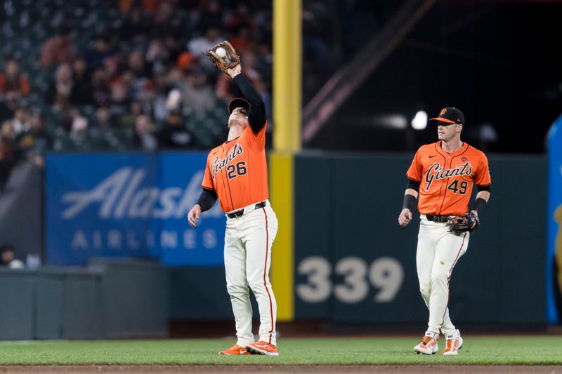 Aug 30, 2024; San Francisco, California, USA; San Francisco Giants shortstop Tyler Fitzgerald (49) watches as  third baseman Matt Chapman (26) catches a deep fly ball against the Miami Marlins during the sixth inning at Oracle Park. Mandatory Credit: John Hefti-USA TODAY Sports
