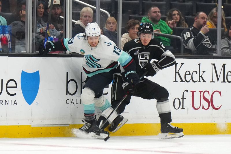 Dec 20, 2023; Los Angeles, California, USA; LA Kings defenseman Jordan Spence (21) and Seattle Kraken left wing Brandon Tanev (13) battle for the puck in the second period at Crypto.com Arena. Mandatory Credit: Kirby Lee-USA TODAY Sports