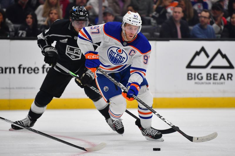 Dec 30, 2023; Los Angeles, California, USA; Edmonton Oilers center Connor McDavid (97) moves the puck ahead of Los Angeles Kings center Anze Kopitar (11) during the first period at Crypto.com Arena. Mandatory Credit: Gary A. Vasquez-USA TODAY Sports
