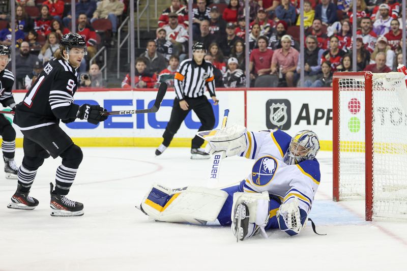 Oct 27, 2023; Newark, New Jersey, USA; Buffalo Sabres goaltender Eric Comrie (31) makes a glove save during the first period in front of New Jersey Devils center Dawson Mercer (91) at Prudential Center. Mandatory Credit: Vincent Carchietta-USA TODAY Sports