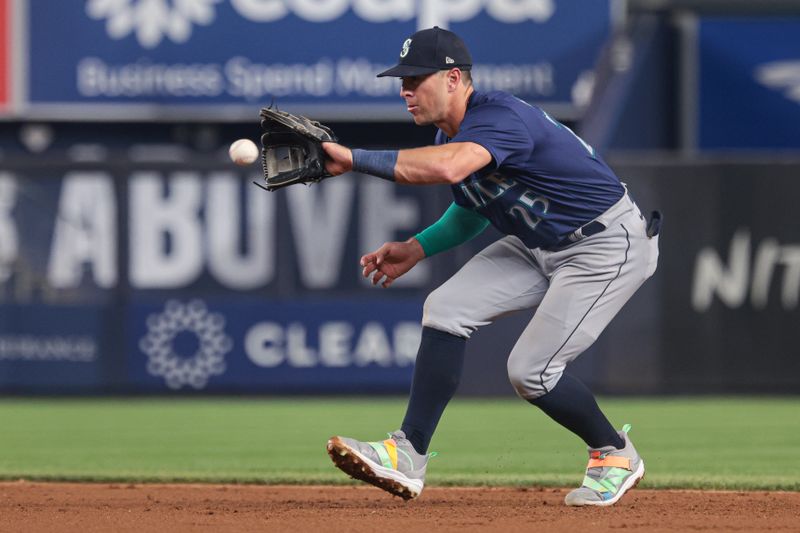 May 21, 2024; Bronx, New York, USA; Seattle Mariners shortstop Dylan Moore (25) fields the ball during the ninth inning against the New York Yankees at Yankee Stadium. Mandatory Credit: Vincent Carchietta-USA TODAY Sports