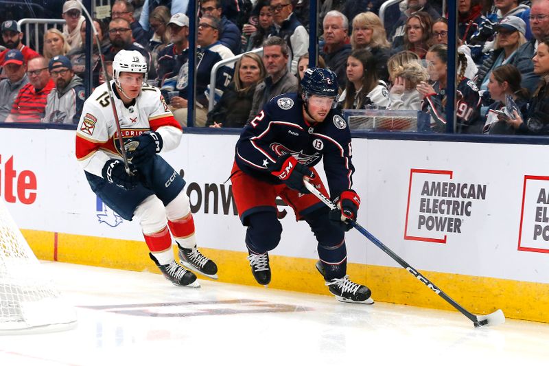 Oct 15, 2024; Columbus, Ohio, USA; Columbus Blue Jackets defenseman Jake Christiansen (2) skates with the puck as Florida Panthers center Anton Lundell (15) trails the play during the first period at Nationwide Arena. Mandatory Credit: Russell LaBounty-Imagn Images