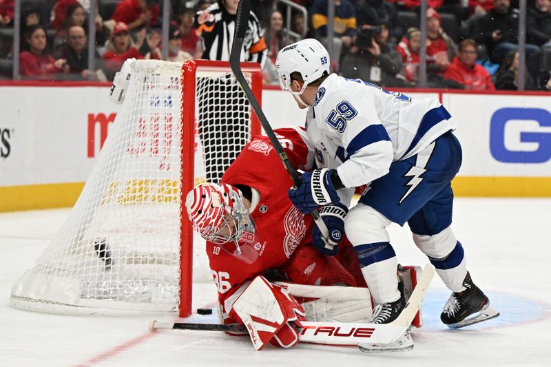 Nov 28, 2025; Detroit, Michigan, USA; Tampa Bay Lightning center Jake Guentzel (59) crashes into Detroit Red Wings goaltender John Gibson (36) after scoring a goal in the third period at Little Caesars Arena. Mandatory Credit: Lon Horwedel-Imagn Images