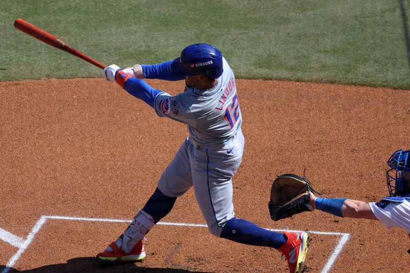 Oct 14, 2024; Los Angeles, California, USA; New York Mets shortstop Francisco Lindor (12) hits a home run against the Los Angeles Dodgers in the first inning during game two of the NLCS for the 2024 MLB Playoffs at Dodger Stadium. Mandatory Credit: Kiyoshi Mio-Imagn Images