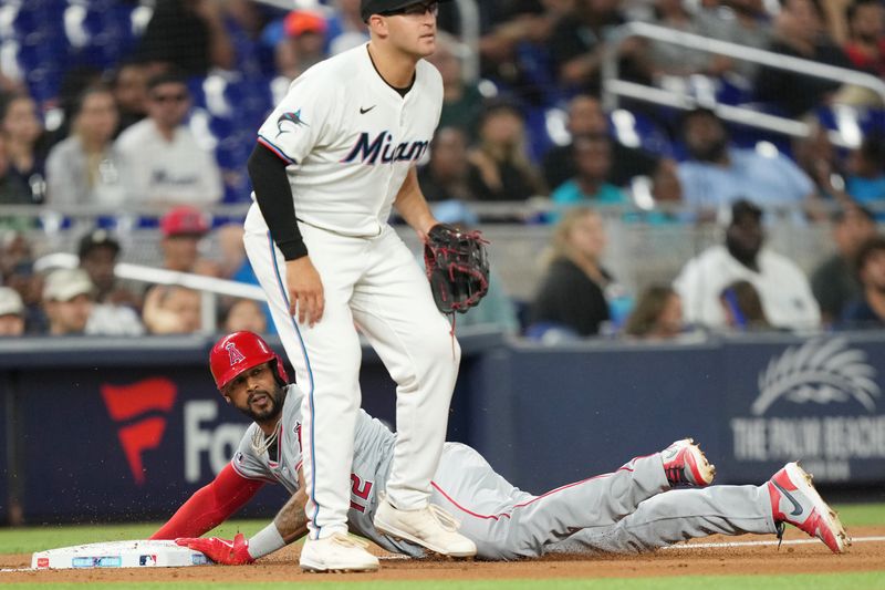 Apr 2, 2024; Miami, Florida, USA; Los Angeles Angels right fielder Aaron Hicks (12) advances to third base in the sixth inning as Miami Marlins third baseman Jonah Bride (41) looks on at loanDepot Park. Mandatory Credit: Jim Rassol-USA TODAY Sports