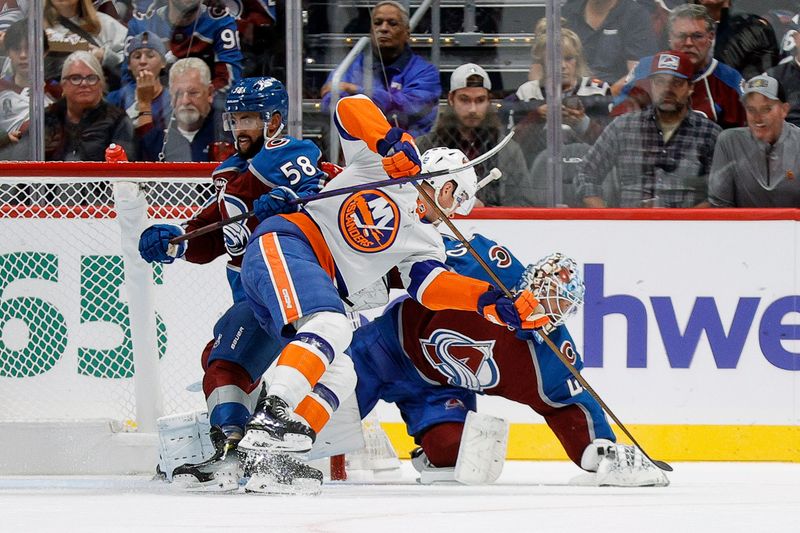 Oct 14, 2024; Denver, Colorado, USA; Colorado Avalanche goaltender Alexandar Georgiev (40) covers the puck as defenseman Oliver Kylington (58) and New York Islanders center Kyle MacLean (32) battle for position in the second period at Ball Arena. Mandatory Credit: Isaiah J. Downing-Imagn Images