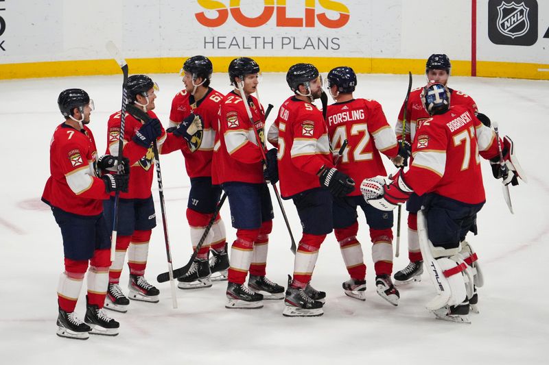 Dec 29, 2023; Sunrise, Florida, USA; Florida Panthers teammates celebrate after defeating the New York Rangers during the third period at Amerant Bank Arena. Mandatory Credit: Jasen Vinlove-USA TODAY Sports