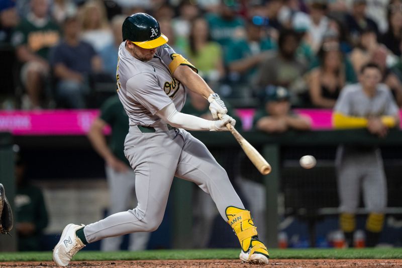 May 11, 2024; Seattle, Washington, USA; Oakland Athletics shortstop Max Schuemann (12) hits a three-run triple during the eighth inning against the Seattle Mariners at T-Mobile Park. Mandatory Credit: Stephen Brashear-USA TODAY Sports