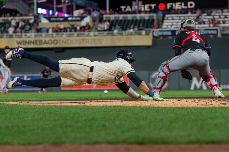 Sep 26, 2024; Minneapolis, Minnesota, USA; Minnesota Twins first base Carlos Santana (30) beats the throw to Miami Marlins catcher Nick Fortes (4) in the eighth inning to tie the game at Target Field. Mandatory Credit: Matt Blewett-Imagn Images