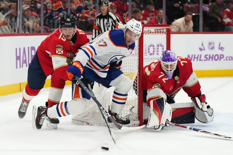 Nov 20, 2023; Sunrise, Florida, USA; Florida Panthers center Anton Lundell (15) reaches for the puck on Edmonton Oilers center Connor McDavid (97) during the first period at Amerant Bank Arena. Mandatory Credit: Jasen Vinlove-USA TODAY Sports