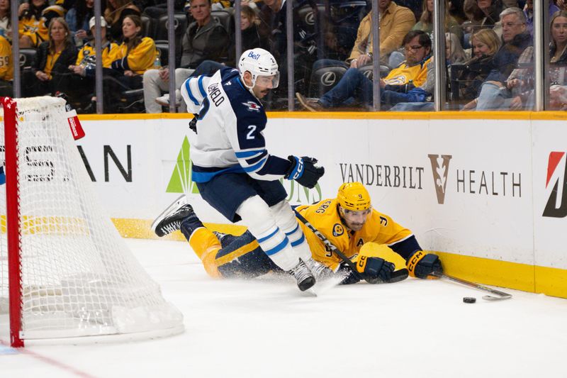 Nov 23, 2024; Nashville, Tennessee, USA;  Nashville Predators left wing Filip Forsberg (9) dives for the puck as Winnipeg Jets defenseman Dylan DeMelo (2) chases during the third period at Bridgestone Arena. Mandatory Credit: Steve Roberts-Imagn Images