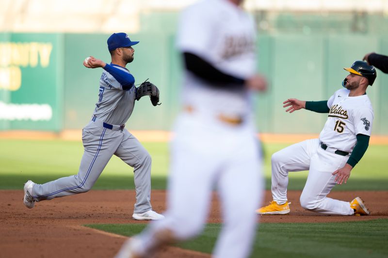 Jun 7, 2024; Oakland, California, USA; Toronto Blue Jays second baseman Isiah Kiner-Falefa (7) throws over Oakland Athletics outfielder Seth Brown (15) to complete a double play during the second inning at Oakland-Alameda County Coliseum. Mandatory Credit: D. Ross Cameron-USA TODAY Sports