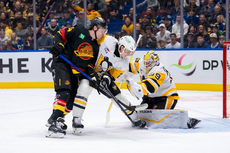 Oct 26, 2024; Vancouver, British Columbia, CAN; Pittsburgh Penguins goalie Alex Nedeljkovic (39) makes a save as defenseman Ryan Graves (27) battles with Vancouver Canucks forward Jake DeBrusk (74) during the first period at Rogers Arena. Mandatory Credit: Bob Frid-Imagn Images