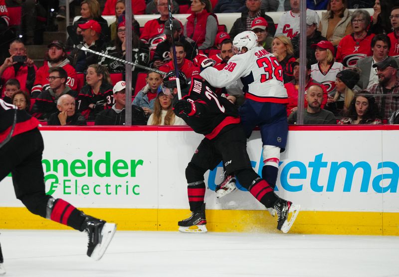 Apr 5, 2024; Raleigh, North Carolina, USA; Carolina Hurricanes right wing Stefan Noesen (23) checks Washington Capitals defenseman Rasmus Sandin (38) during the first period at PNC Arena. Mandatory Credit: James Guillory-USA TODAY Sports