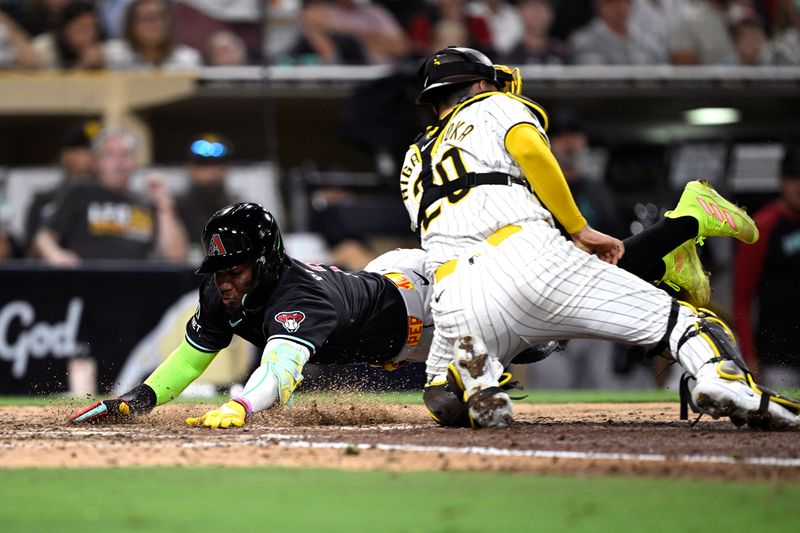 Jul 6, 2024; San Diego, California, USA; Arizona Diamondbacks shortstop Geraldo Perdomo (2) slides home to score a run ahead of the tag by San Diego Padres catcher Kyle Higashioka (20) during the tenth inning at Petco Park. Mandatory Credit: Orlando Ramirez-USA TODAY Sports