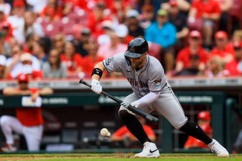 May 9, 2024; Cincinnati, Ohio, USA; Arizona Diamondbacks catcher Tucker Barnhart (16) bunts against the Cincinnati Reds in the second inning at Great American Ball Park. Mandatory Credit: Katie Stratman-USA TODAY Sports