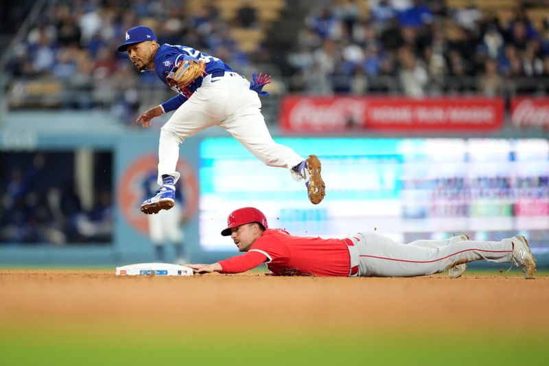 Mar 25, 2024; Los Angeles, California, USA; Los Angeles Angels first baseman Nolan Schanuel (18) slides into second base beneath the tag of Los Angeles Dodgers right fielder Mookie Betts (50) for a stolen base in the fourth inning at Dodger Stadium. Mandatory Credit: Kirby Lee-USA TODAY Sports