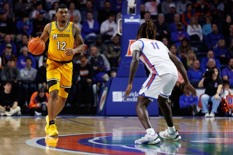 Jan 14, 2025; Gainesville, Florida, USA; Missouri Tigers guard Tony Perkins (12) dribbles the ball at Florida Gators guard Denzel Aberdeen (11) during the first half at Exactech Arena at the Stephen C. O'Connell Center. Mandatory Credit: Matt Pendleton-Imagn Images