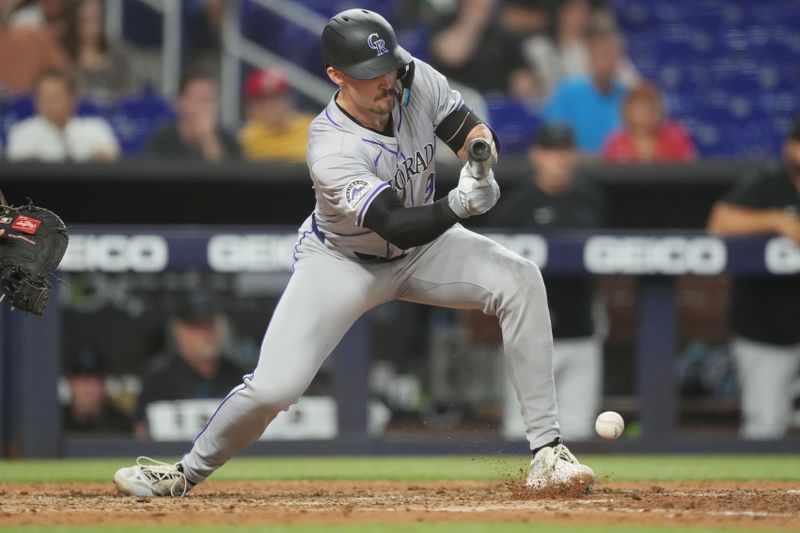 May 2, 2024; Miami, Florida, USA;  Colorado Rockies center fielder Brenton Doyle (9) bunts in th tenth inning against the Miami Marlins at loanDepot Park. Mandatory Credit: Jim Rassol-USA TODAY Sports