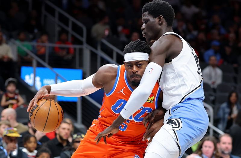 ATLANTA, GEORGIA - FEBRUARY 28:  Luguentz Dort #5 of the Oklahoma City Thunder drives against Mouhamed Gueye #18 of the Atlanta Hawks during the first quarter at State Farm Arena on February 28, 2025 in Atlanta, Georgia.  NOTE TO USER: User expressly acknowledges and agrees that, by downloading and or using this photograph, User is consenting to the terms and conditions of the Getty Images License Agreement.  (Photo by Kevin C. Cox/Getty Images)