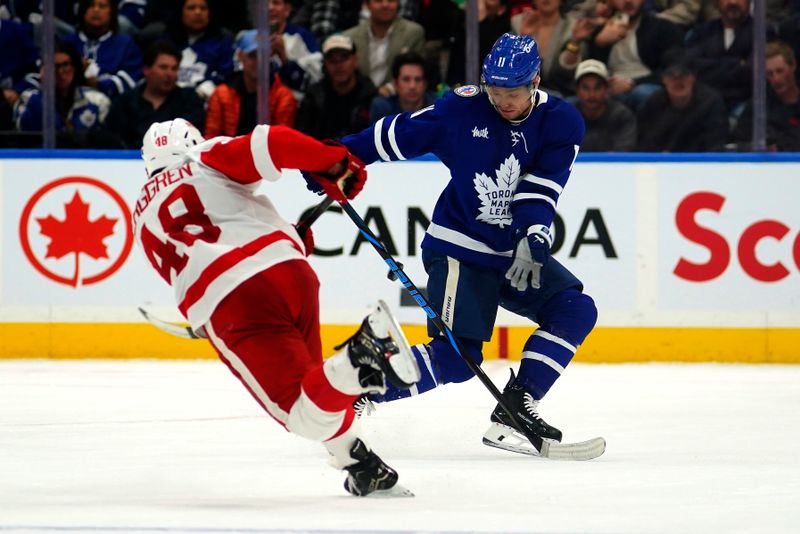 Nov 8, 2024; Toronto, Ontario, CAN; Toronto Maple Leafs forward Max Domi (11) blocks a shot by Detroit Red Wings forward Jonatan Berggren (48) during the third period at Scotiabank Arena. Mandatory Credit: John E. Sokolowski-Imagn Images