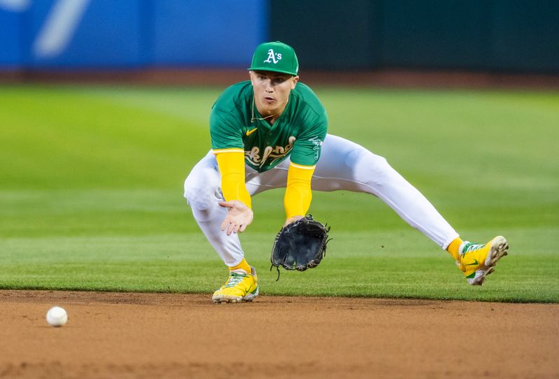 Sep 20, 2024; Oakland, California, USA; Oakland Athletics second base Zack Gelof (20) fields a grounder during the third inning against the New York Yankees at Oakland-Alameda County Coliseum. Mandatory Credit: Bob Kupbens-Imagn Images