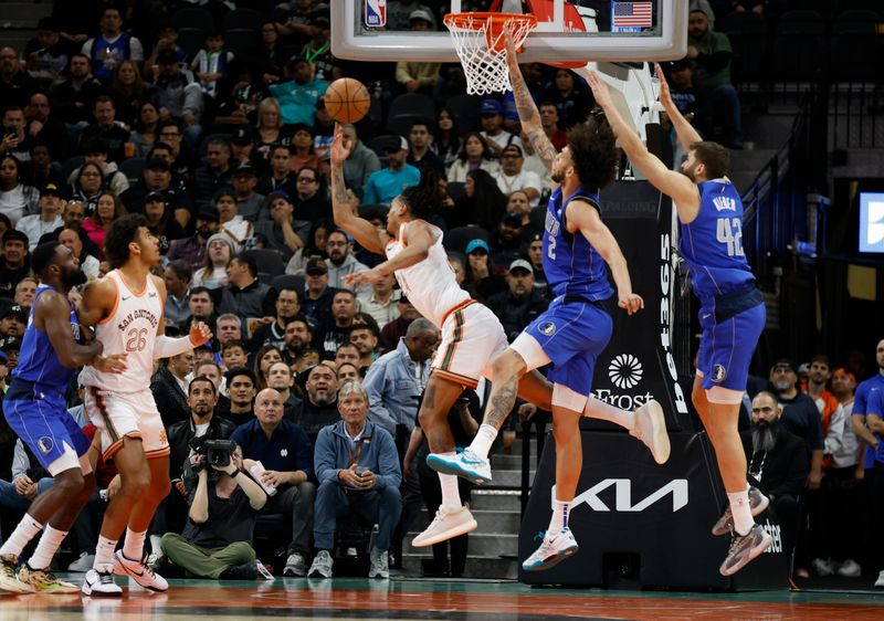 SAN ANTONIO, TX - MARCH 19:  Devin Vassell #24 of the San Antonio Spurs scores on a reverse lay-up past Dereck Lively III #2 of the Dallas Mavericks in the second half at Frost Bank Center on March 19, 2024 in San Antonio, Texas. NOTE TO USER: User expressly acknowledges and agrees that, by downloading and or using this photograph, User is consenting to terms and conditions of the Getty Images License Agreement. (Photo by Ronald Cortes/Getty Images)