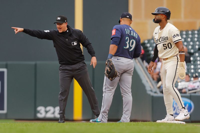 Jun 26, 2025; Minneapolis, Minnesota, USA; First base umpire Brennan Miller directs Minnesota Twins left fielder Willi Castro (50) to second base after a balk by the Seattle Mariners pitcher for throwing to first baseman Donovan Solano (39) on a disengagement violation in the fifth inning at Target Field. Mandatory Credit: Bruce Kluckhohn-Imagn Images