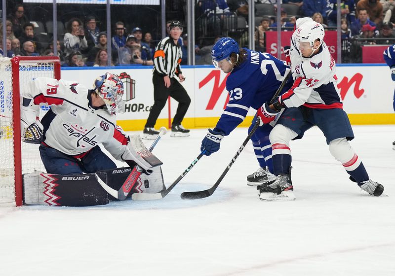 Dec 6, 2024; Toronto, Ontario, CAN; Toronto Maple Leafs left wing Matthew Knies (23) battles for the puck with Washington Capitals defenseman Martin Fehervary (42) in front of goaltender Charlie Lindgren (79) during the first period at Scotiabank Arena. Mandatory Credit: Nick Turchiaro-Imagn Images