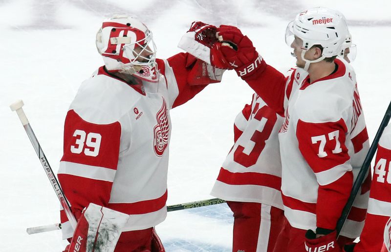 Nov 13, 2024; Pittsburgh, Pennsylvania, USA;  Detroit Red Wings goaltender Cam Talbot (39) and defenseman Simon Edvinsson (77) celebrate after defeating the Pittsburgh Penguins in overtime at PPG Paints Arena. Mandatory Credit: Charles LeClaire-Imagn Images