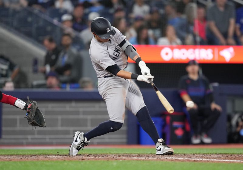 Jun 28, 2024; Toronto, Ontario, CAN; New York Yankees infielder Oswaldo Cabrera (95) hits a RBI double against the Toronto Blue Jays during the ninth inning at Rogers Centre. Mandatory Credit: Nick Turchiaro-USA TODAY Sports