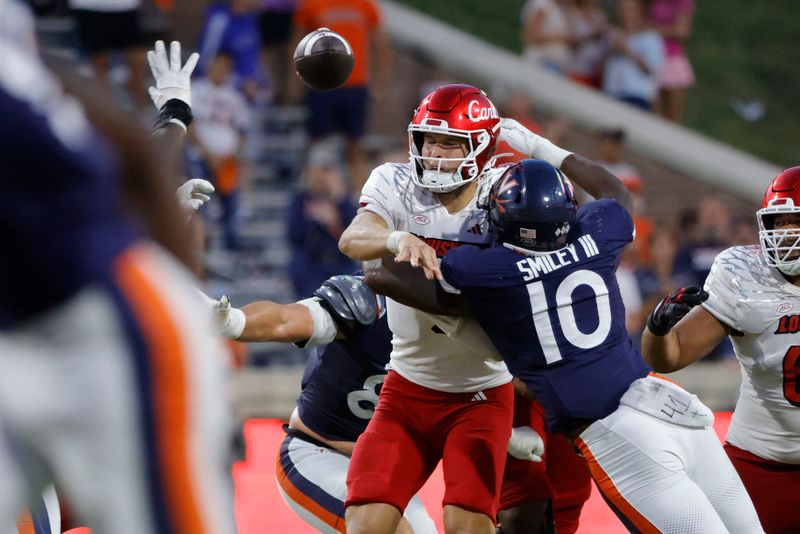 Oct 12, 2024; Charlottesville, Virginia, USA; Louisville Cardinals quarterback Tyler Shough (9) throws the ball as Virginia Cavaliers defensive end Ben Smiley III (10) defends during the second half at Scott Stadium. Mandatory Credit: Amber Searls-Imagn Images