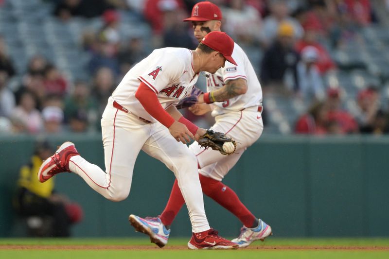 Jun 9, 2025; Anaheim, California, USA;   Los Angeles Angels third baseman Kevin Newman (10) fields a grounder in front of shortstop Zach Neto (9) and throws Athletics second baseman Luis Urias (17) out at first in the fifth inning at Angel Stadium. Mandatory Credit: Jayne Kamin-Oncea-Imagn Images
