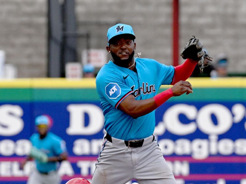 Mar 1, 2024; Clearwater, Florida, USA; Miami Marlins second baseman Vital Brujan (17) throws to first base as Philadelphia Phillies first baseman Bryce Harper (3) slides  in the first inning at BayCare Ballpark. Mandatory Credit: Jonathan Dyer-USA TODAY Sports