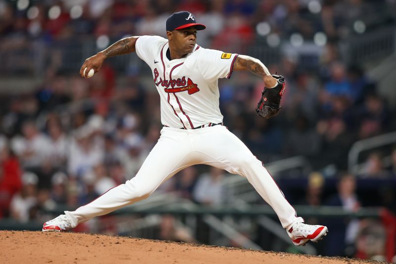 Apr 24, 2024; Atlanta, Georgia, USA; Atlanta Braves relief pitcher Raisel Iglesias (26) throws against the Miami Marlins in the ninth inning at Truist Park. Mandatory Credit: Brett Davis-USA TODAY Sports
