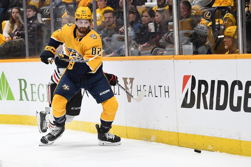 Jan 2, 2024; Nashville, Tennessee, USA; Nashville Predators center Tommy Novak (82) plays the puck behind the net during the second period against the Chicago Blackhawks at Bridgestone Arena. Mandatory Credit: Christopher Hanewinckel-USA TODAY Sports