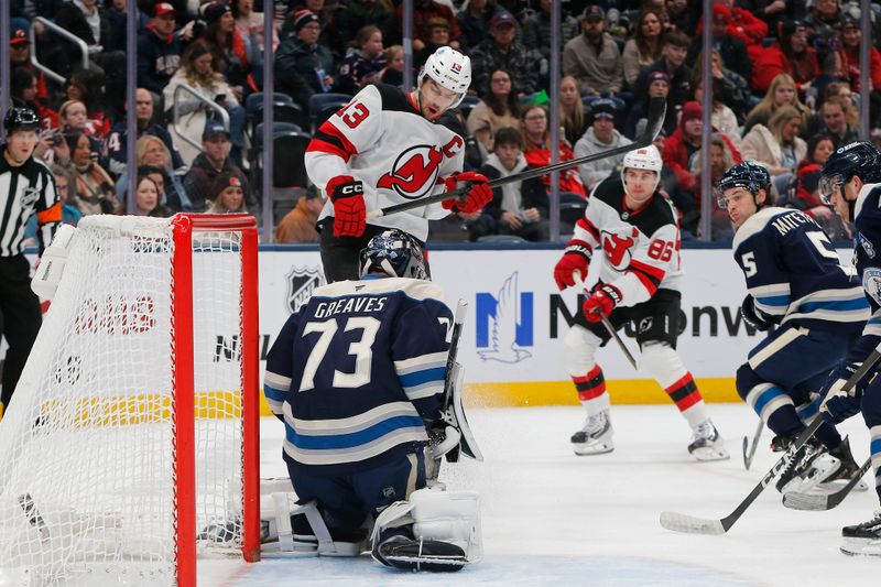 Dec 31, 2025; Columbus, Ohio, USA; Columbus Blue Jackets goalie Jet Greaves (73) makes a save as New Jersey Devils center Nico Hischier (13) looks for a rebound during the first period at Nationwide Arena. Mandatory Credit: Russell LaBounty-Imagn Images