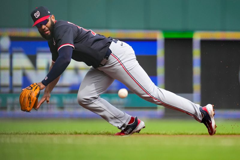 May 4, 2025; Cincinnati, Ohio, USA;  Washington Nationals third baseman Amed Rosario (13) attempts to field a hit by Cincinnati Reds second baseman Matt McLain (9) in the first inning inning at Great American Ball Park. Mandatory Credit: Aaron Doster-Imagn Images